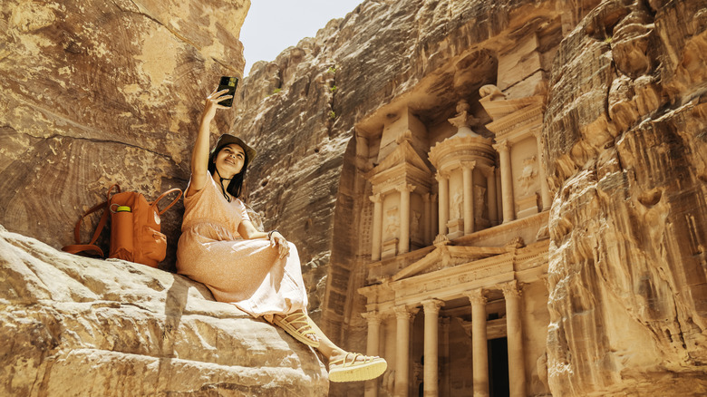 A traveler taking a selfie at the Treasury in Petra, shooting location for 