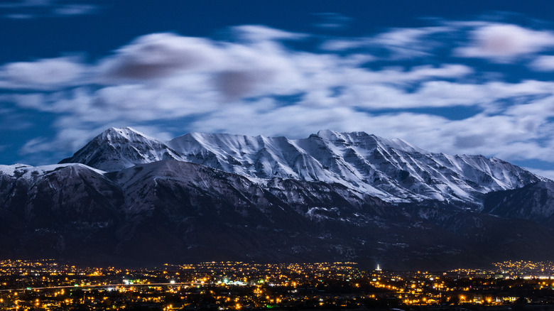 Aerial view of Lehi, Utah at night with mountains and clouds in the background.